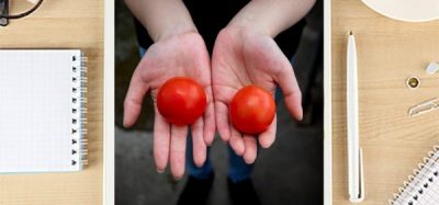 Laptop with hands holding tomatoes