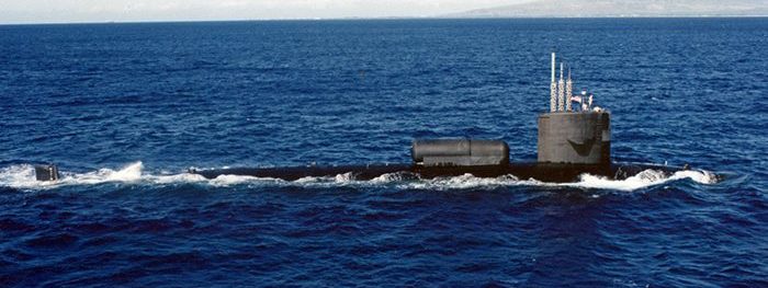 A photograph of the USS William H. Bates (SSN-680) submerged in the ocean with light filtering down from the surface. The author, Darin Detwiler, served on this submarine.