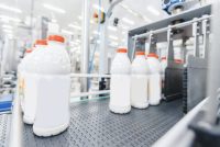 Milk bottles on a production line, illustrating real-time quality control with Process NIR in food manufacturing