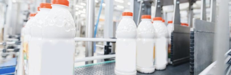 Milk bottles on a production line, illustrating real-time quality control with Process NIR in food manufacturing