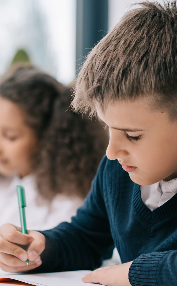 boy writing for school milk