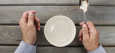 Hungry man waiting for his meal over empty bowl on wooden table.