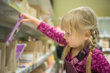 girl looking at supermarket shelf