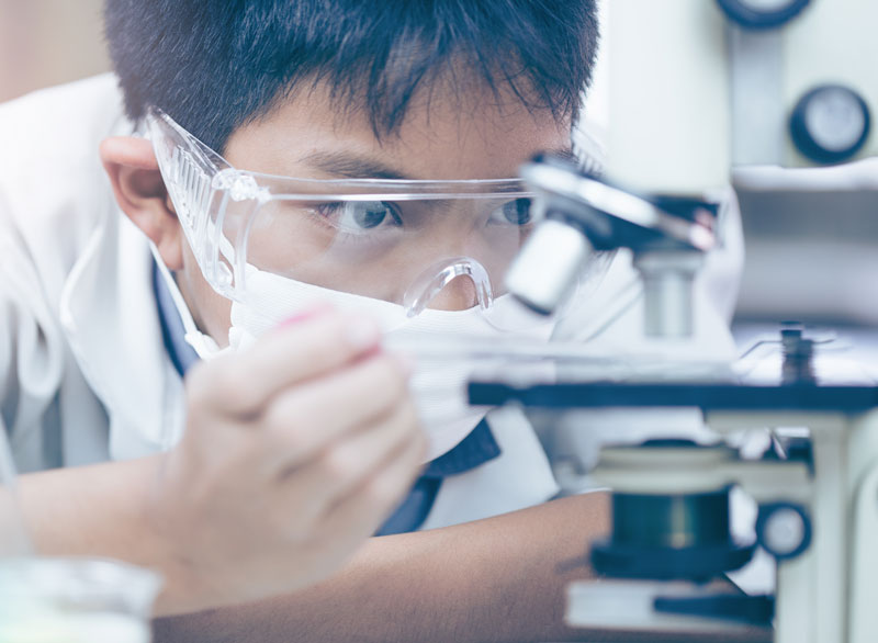 man looking at microscope