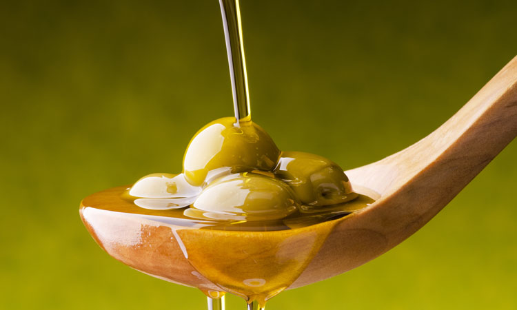 Olive oil poured on spoon