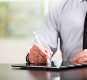 business man writing on tablet