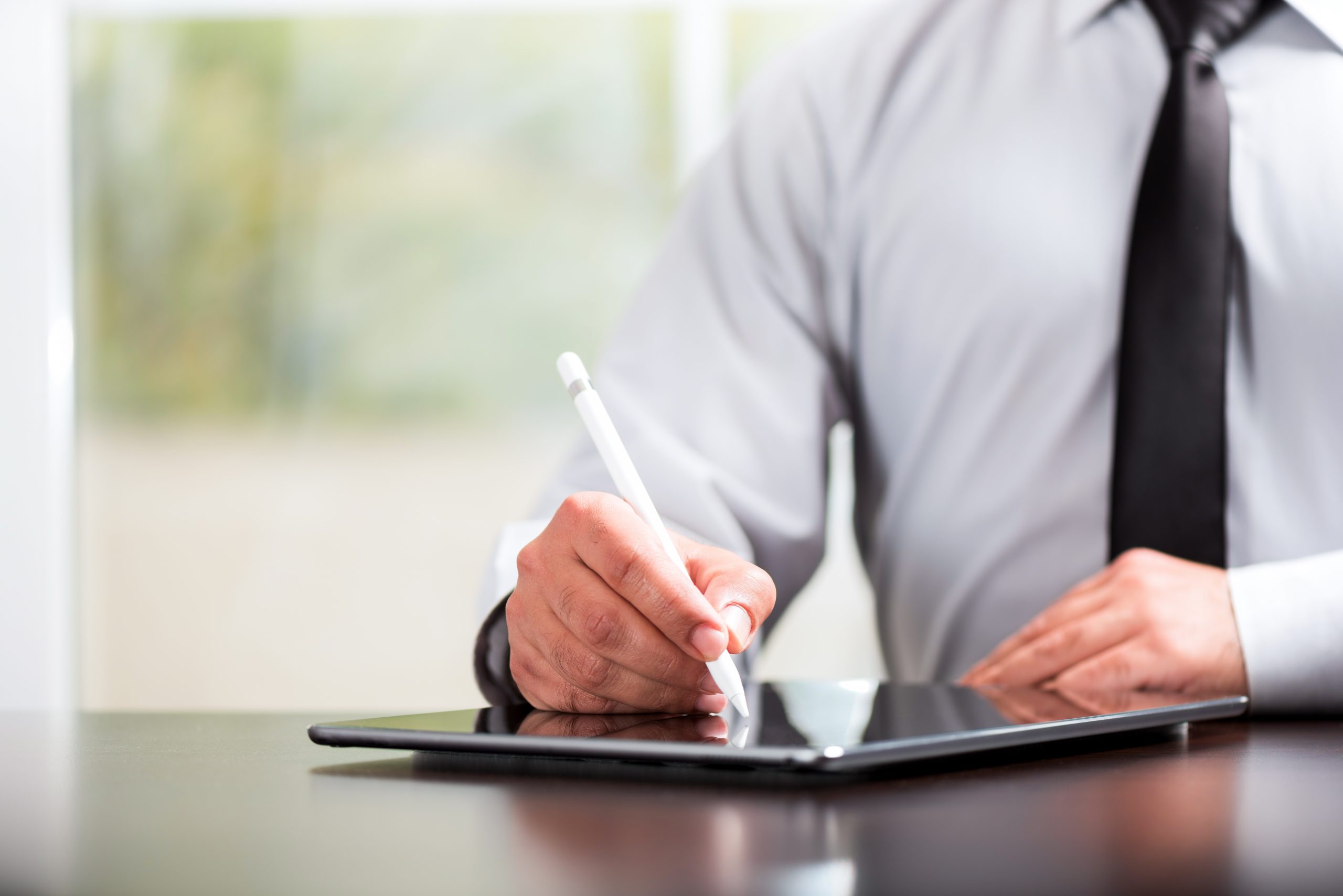 business man writing on tablet