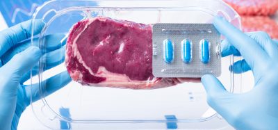 steak being held by blue gloves