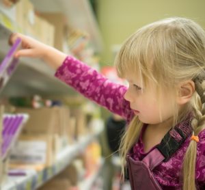 child picking chocolate from shelf