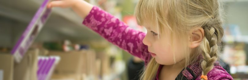 child picking chocolate from shelf