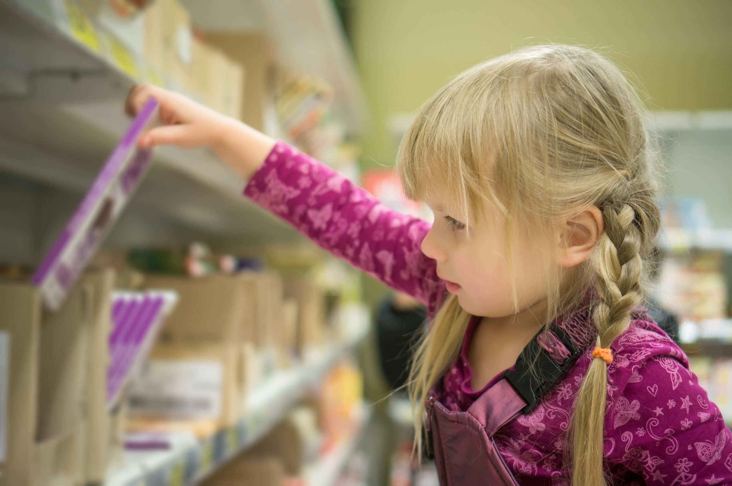 child picking chocolate from shelf
