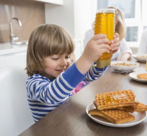 squeezing honey onto waffles