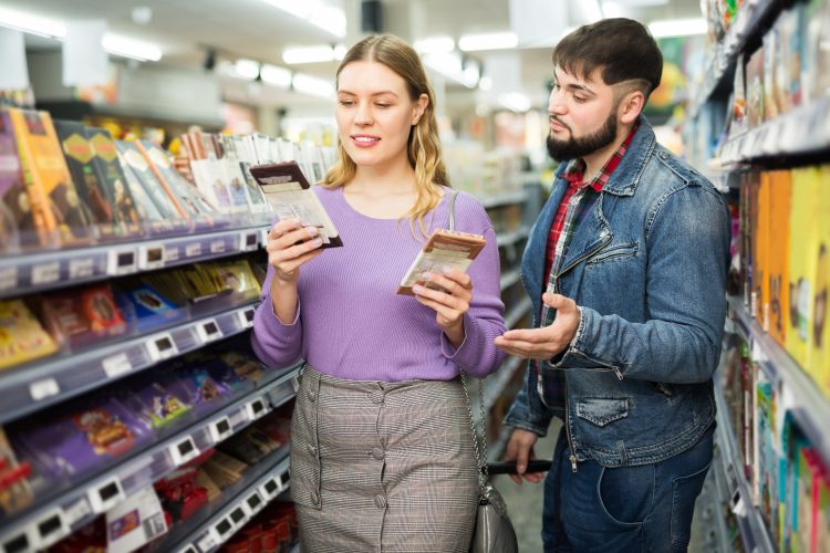 couple buying chocolate in shop