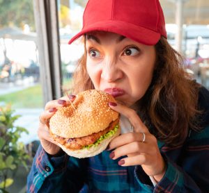 woman sniffing burger