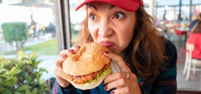 woman sniffing burger
