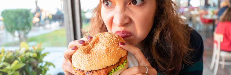 woman sniffing burger