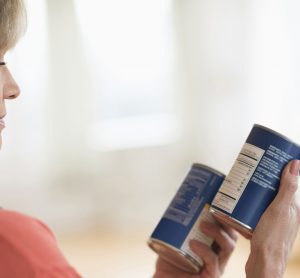 lady comparing canned food