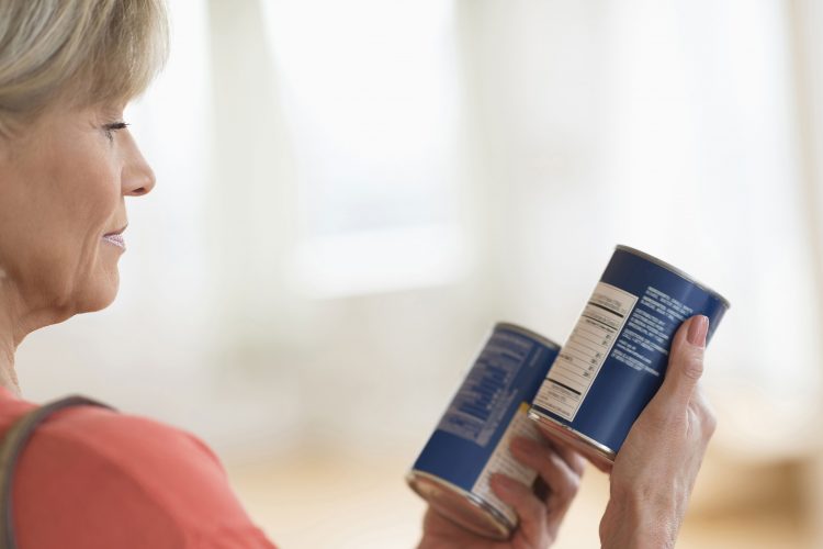 lady comparing canned food