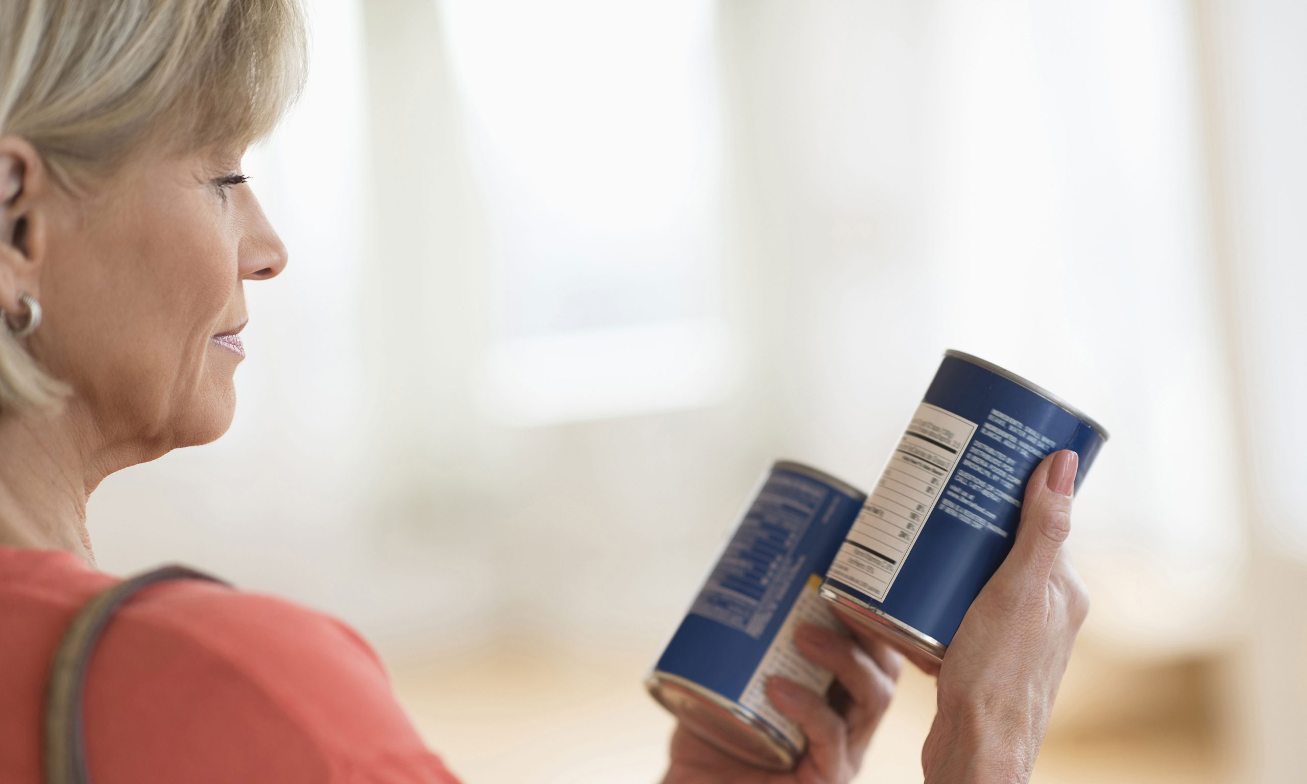 lady comparing canned food