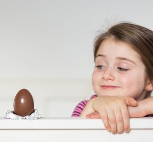 Girl looking at chocolate Easter egg