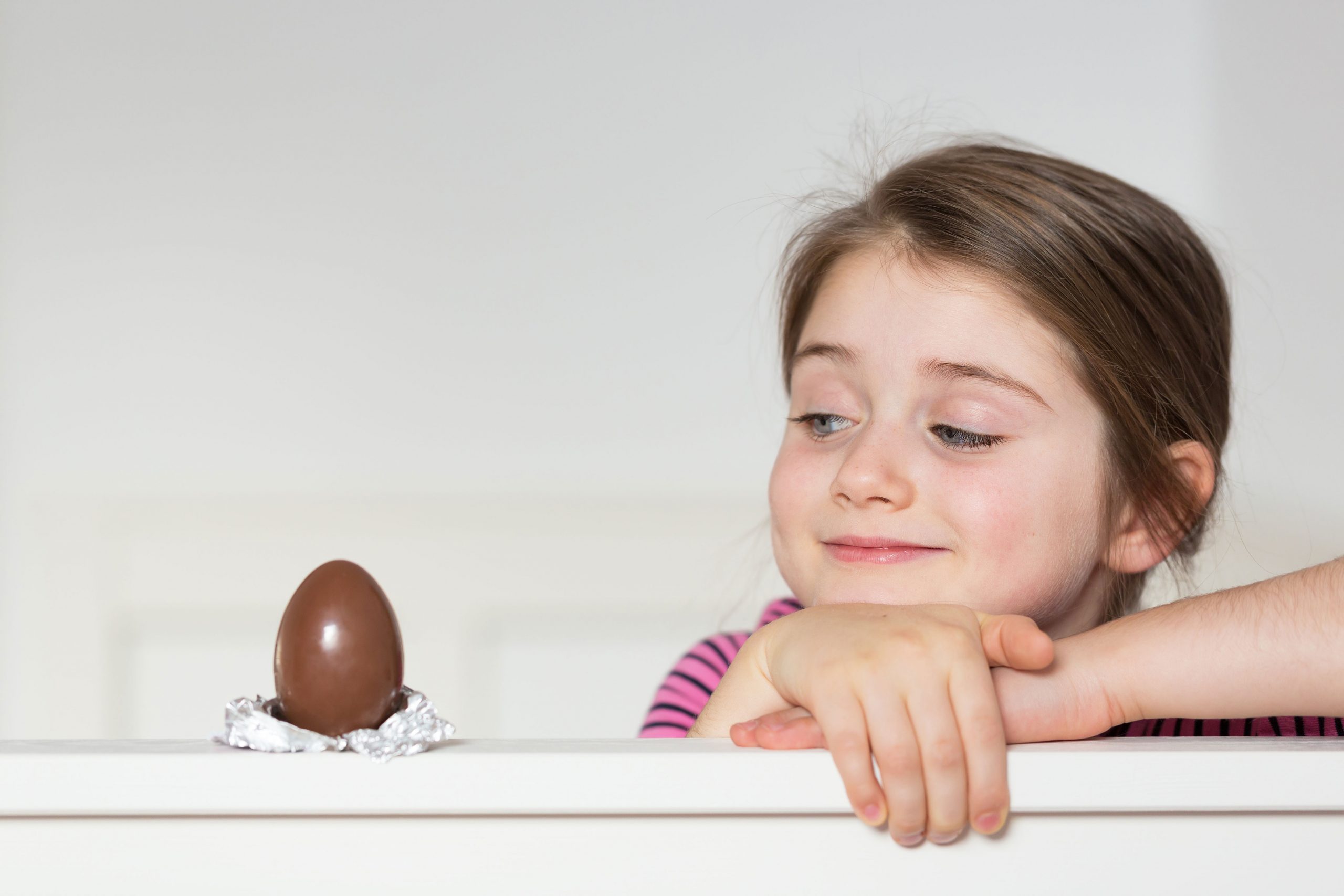 Girl looking at chocolate Easter egg