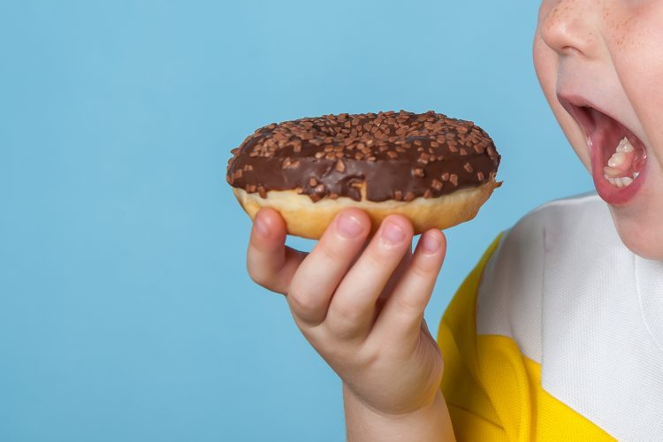 child eating doughnut