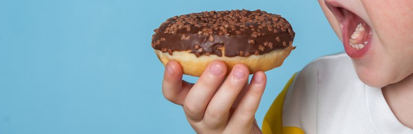 child eating doughnut