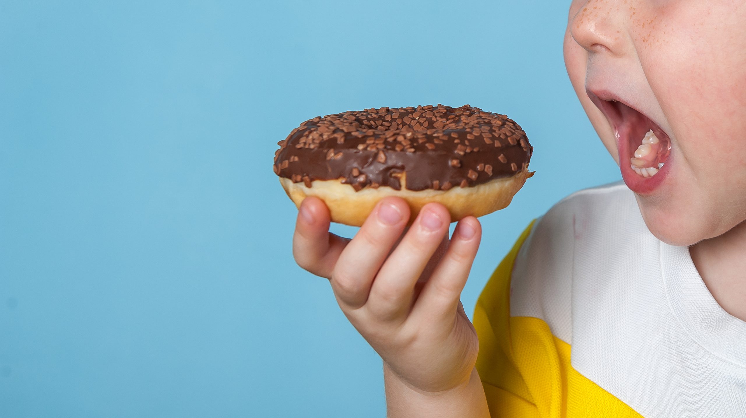child eating doughnut