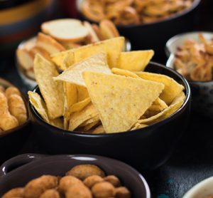 Salty snack including peanuts, potato chips and pretzels served as party food in bowls