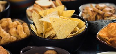 Salty snack including peanuts, potato chips and pretzels served as party food in bowls