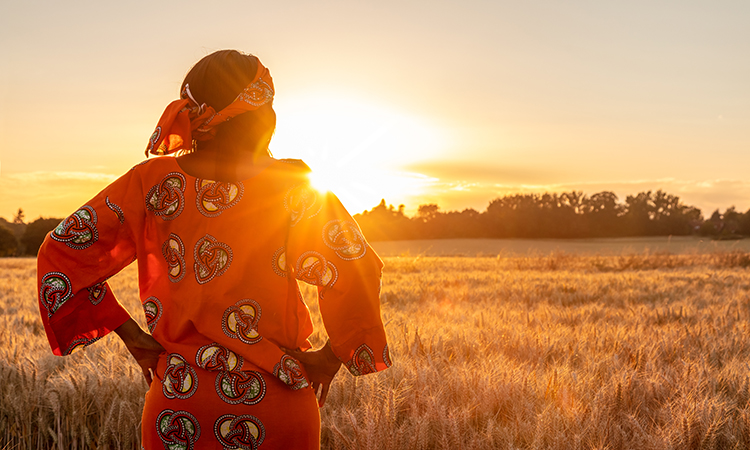 agricultrice regardant au-dessus de sa ferme en Afrique